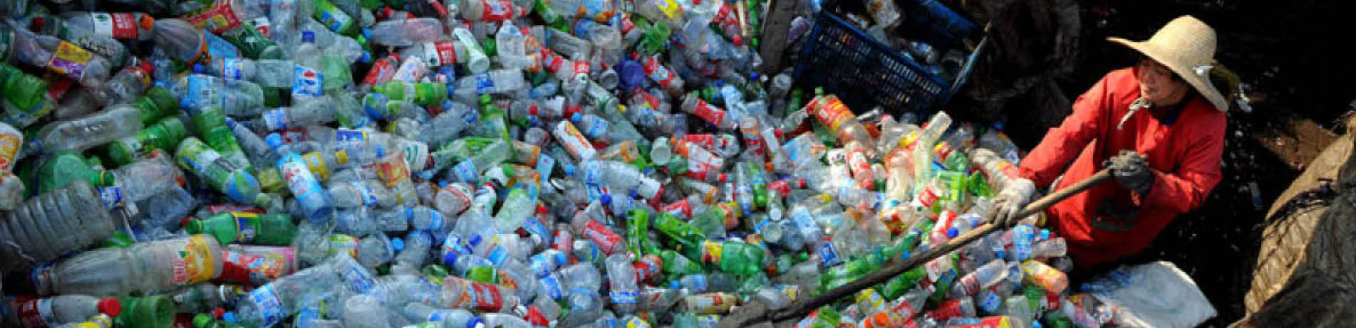 A person in China sifting through a large pile of plastic waste